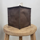 dark Brown leather tissue box cover on a wooden stool against a plain background