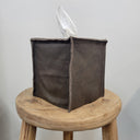 Brown with Burnished Black Leather Single Tissue Box Cover on a wooden stool against a plain background