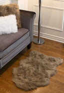Gray sofa with fur throw and rug on wooden floor