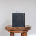 dark leather tissue box cover on a wooden table with a white background