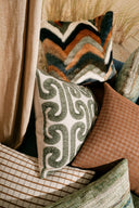 Decorative pillows with various patterns and colors on a couch.