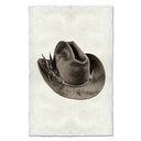 Brown cowboy hat with a feather on a textured white background