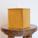 Yellow tissue box cover on a wooden table with a white background
