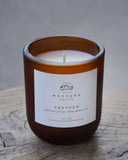 Candle with a label on a wooden surface