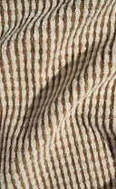 A close-up of a textured fabric with vertical wavy stripes in brown and cream.