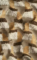 A close-up of a textured woven fabric with a geometric pattern in beige, brown, and off-white.