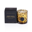 Candle with amber and black print design and matching box labeled 'Apothecary Guild' on a white background