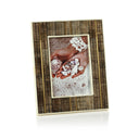 A rectangular picture frame with a textured brown and beige bone pattern border and a cream-colored horn inner frame, holding a photograph of hands holding seashells on a sandy beach.