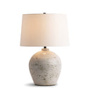 Adam Table lamp with a textured ceramic base and white shade on a white background
