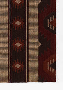 Close-up of a patterned red and brown fabric with geometric designs on a white background