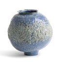 A round ceramic vase with a textured, bubble-patterned glaze in shades of blue, gray, and white, set against a plain white background.