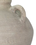Close-up of a textured stone vase with a handle on a white background