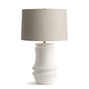 Clint Table lamp with a white ceramic base and beige fabric shade on a white background