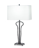 A table lamp with a large white rectangular shade and a dark textured metal base featuring curved, branch-like legs on a white background.