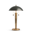 Table lamp with black shade and brass base on a white background