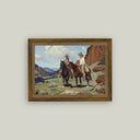 Framed western art print of two cowboys on horseback in a red canyon landscape, in a rustic wood frame.