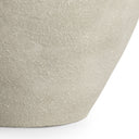 Close-up of a textured ceramic planter pot in a light warm gray-beige tone, showing the curved side and base against a white background.