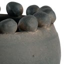 Close-up of a stone bowl with spherical protrusions on a white background