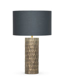 A table lamp with a dark charcoal gray fabric drum shade and a textured metallic gold base featuring a hexagonal honeycomb pattern, shown on a solid white background.