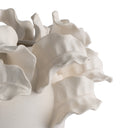 White ceramic vase with wavy design on a white background