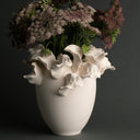 White floral-patterned vase with a bouquet of flowers on a dark background