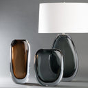 Two modern glass vases with a lamp on a gray background