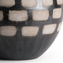 Close-up of a black ceramic table lamp base with geometric pattern on a white background