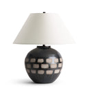 Table lamp with a checkered design base and white shade on a white background