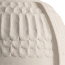 Close-up of a textured ceramic vessel in a warm off-white or cream tone, showing a ribbed, scalloped surface detail against a plain white background.