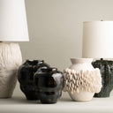 Vases and lamps with textured surfaces on a neutral background