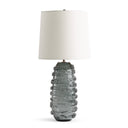 Table lamp with textured gray glass base and white shade on a white background