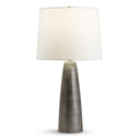 Table lamp with a textured base and white shade on a white background