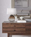 Wooden dresser with decorative items including Oriole Table Lamp and books, against a neutral wall.