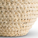 Close-up of a woven corn husk beige lamp base on a light gray backgroundase