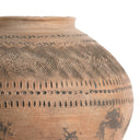 Close-up of a terracotta pot with geometric patterns on a white background