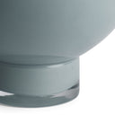 Close-up of a gray vase with a clear glass base on a white background