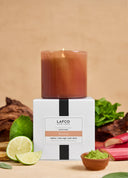 LAFCO candle with packaging on a table with limes and mint leaves