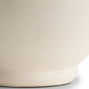 Close-up of a textured beige ceramic lamp base on a white background