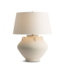 Beige ceramic table lamp with a white lampshade on a white background