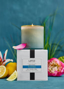 Lafco candle with packaging on a blue background with flowers and lemons