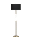 A modern floor lamp with a black drum shade, a brushed brass-finished metal stand, and a clear cylindrical glass accent in the center, shown against a plain white background.