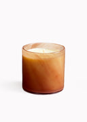 Candle in a brown glass container on a white background