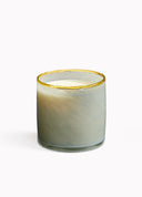Candle in a glass container with a gold rim on a white background